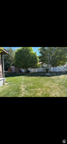 1025 North 300 West, Unit 16 Springville, UT 84663 - Photo 3 of 8 Expansive grassy yard featuring mature trees and a white picket fence