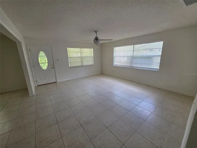 an empty room with windows and fireplace