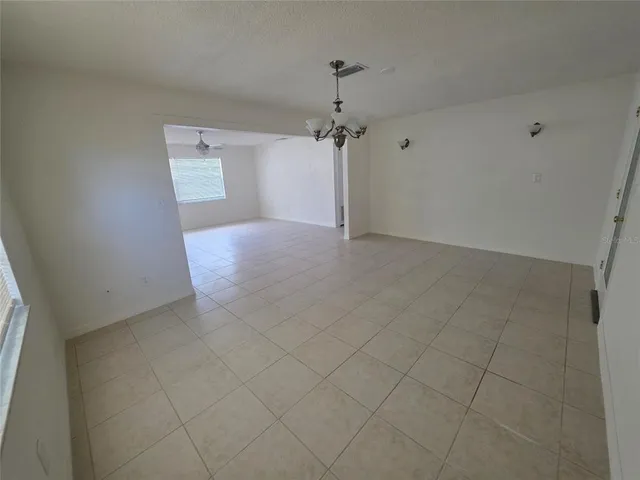 a view of a hallway with a chandelier fan