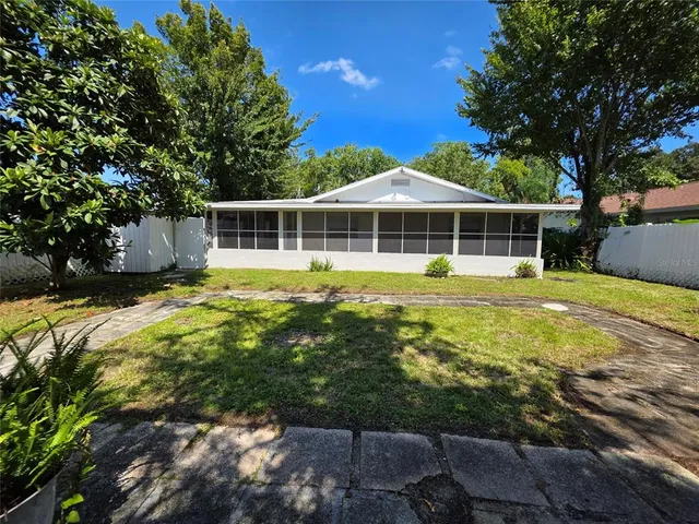 a view of a house with backyard and sitting area