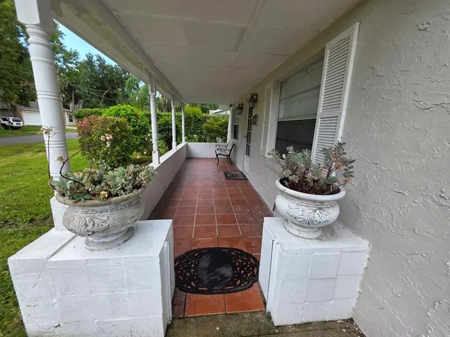 a front view of a house with fountain fountain plants and large tree