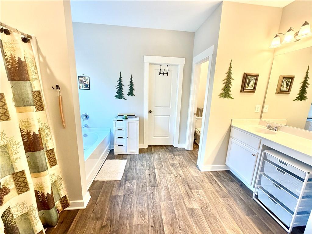 386 Westminster Trail Winder, GA 30680 - Photo 14 of 20 a view of a bathroom with sink and wooden floor