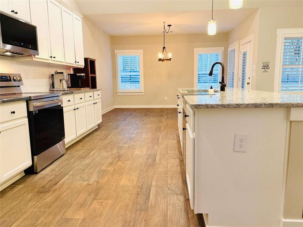386 Westminster Trail Winder, GA 30680 - Photo 10 of 20 a large kitchen with cabinets and wooden floor