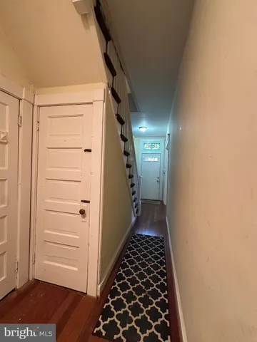 a view of a hallway with wooden floor and staircase