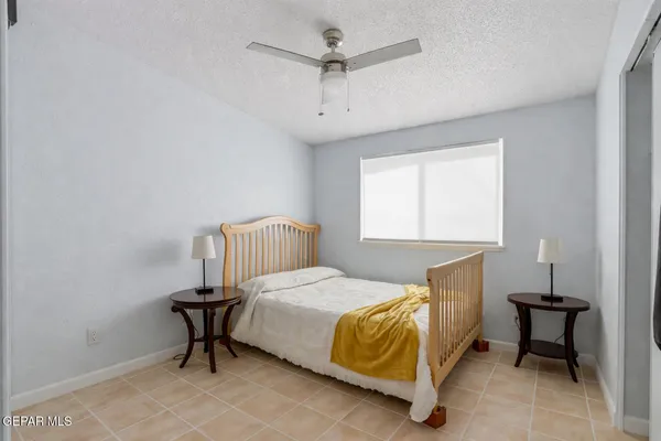 a bedroom with a bed table chair and a window
