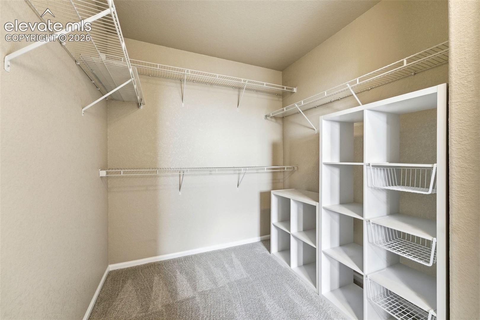 7274 Red Cardinal Loop Colorado Springs, CO 80908 - Photo 22 of 33 Built-in closet organization system featuring wire shelving, wire hanging rods, and modular cube storage units with integrated wire baskets