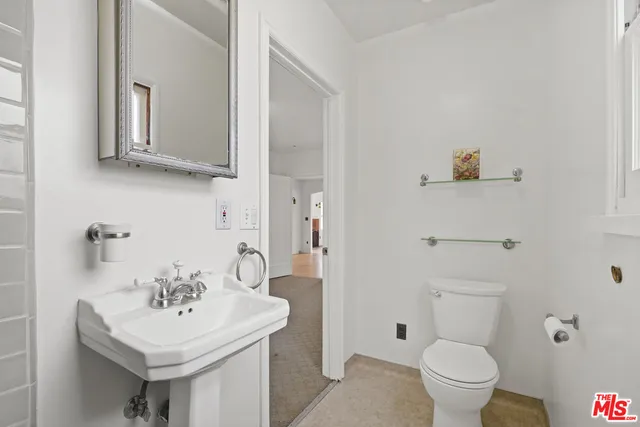 a bathroom with a sink toilet and mirror