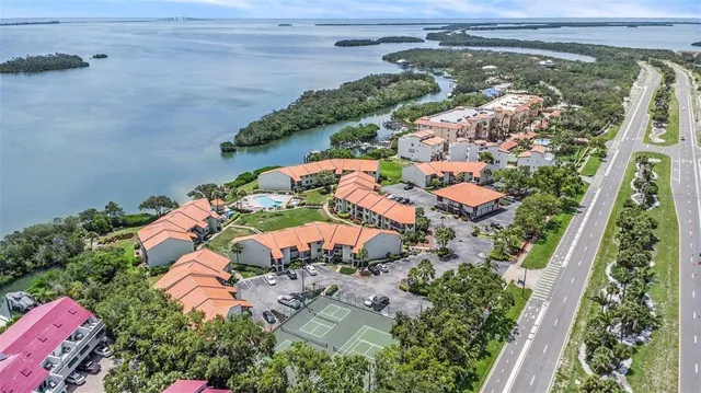 a kitchen with stainless steel appliances granite countertop a sink a stove a refrigerator and island with wooden floor