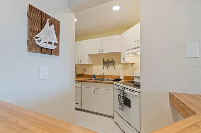 a large living room with stainless steel appliances granite countertop couches a fireplace and wooden floor