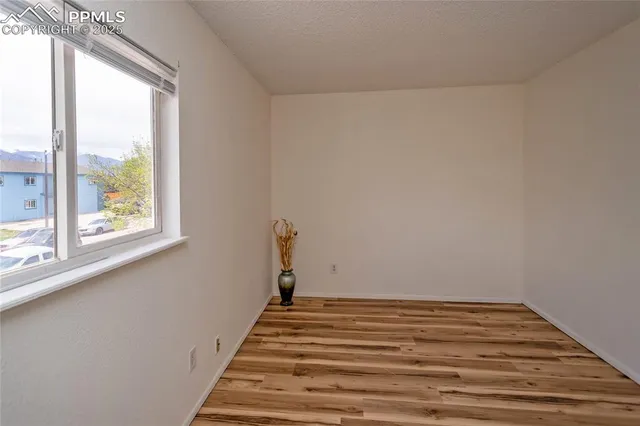 a view of a room with wooden floor and windows