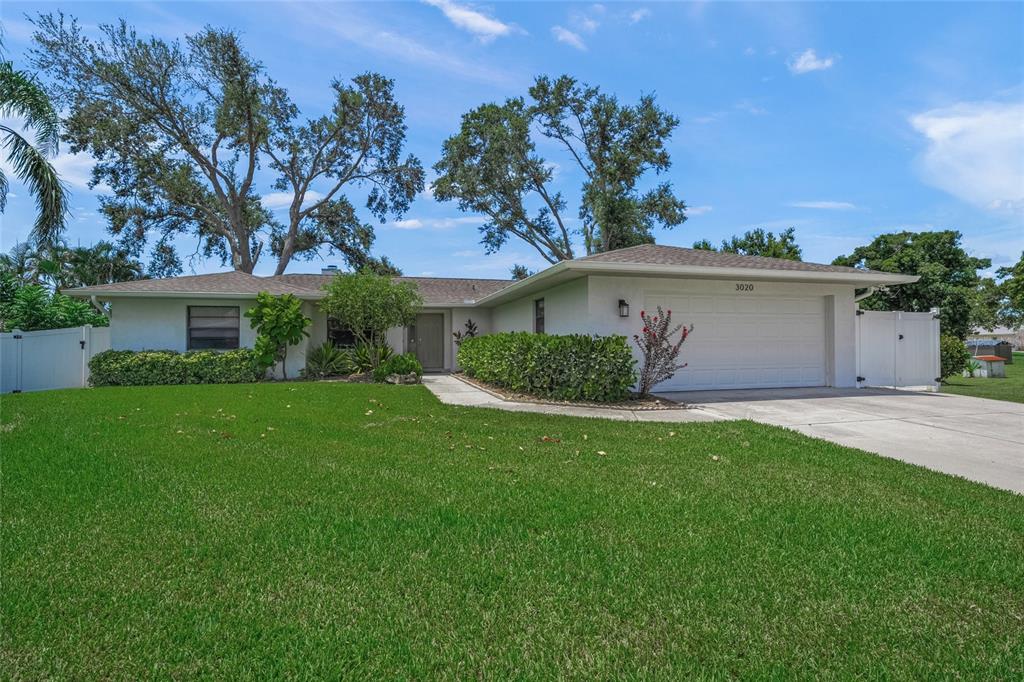 a view of a house with a yard and potted plants