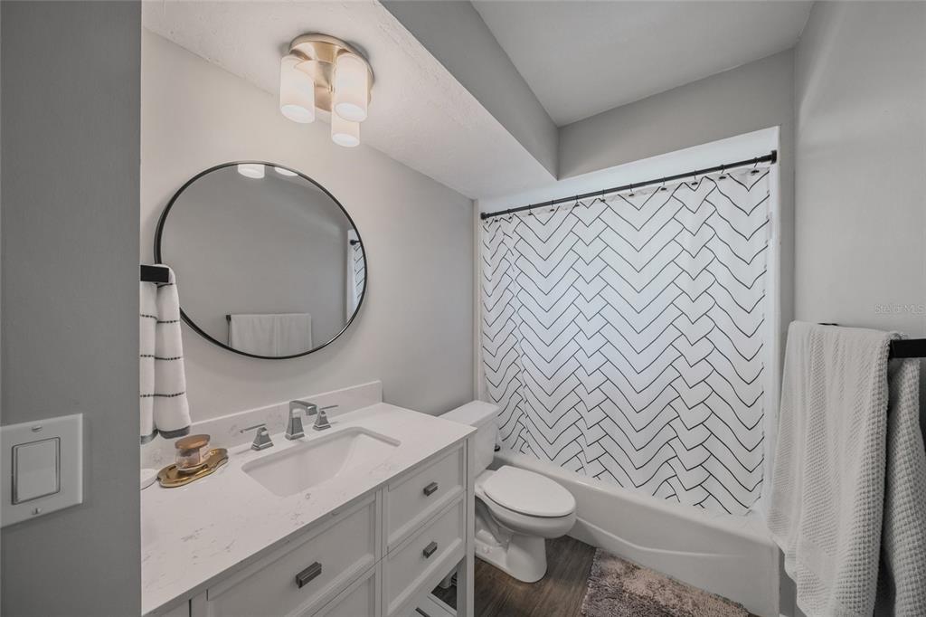 3020 Gypsy Street Sarasota, FL 34231 - Photo 18 of 34 a bathroom with a toilet sink vanity and mirror