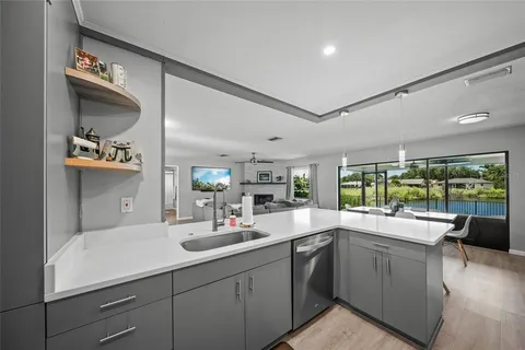 a kitchen with stainless steel appliances a sink a stove a table and chairs