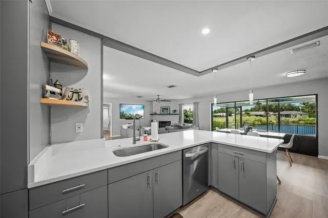 a kitchen with stainless steel appliances a sink a stove a table and chairs