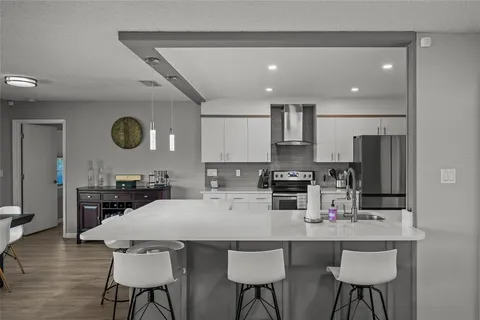 a large kitchen with kitchen island a dining table chairs stainless steel appliances and cabinets