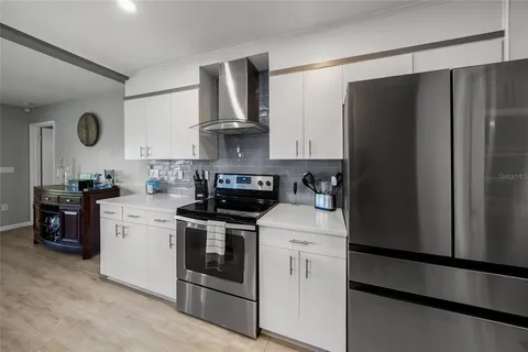 a kitchen with sink a refrigerator and wooden floor