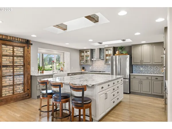 a kitchen with stainless steel appliances kitchen island granite countertop a sink and cabinets