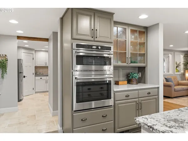 a kitchen with white cabinets and refrigerator