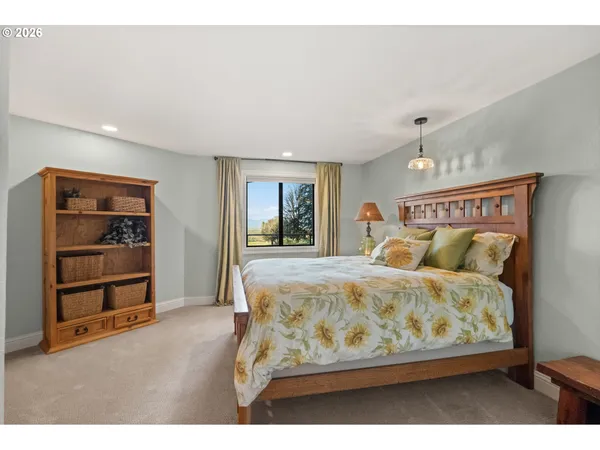 a bedroom with a bed and a table in it with wooden floor