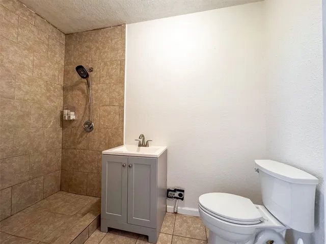 a bathroom with a toilet a sink a shower and mirror