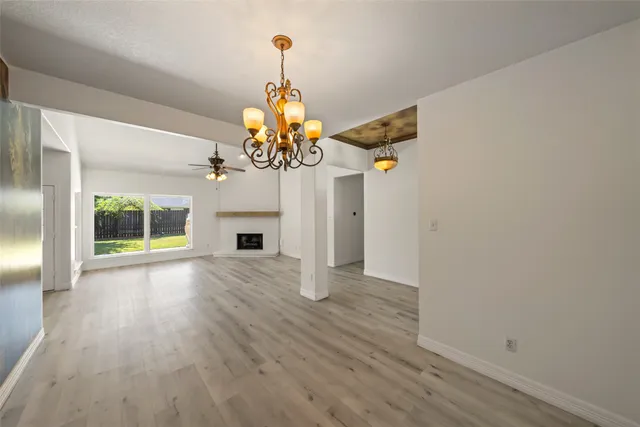 a view of a livingroom with wooden floor and a chandelier