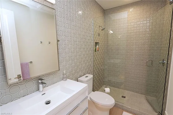 a bathroom with a sink shower and a toilet