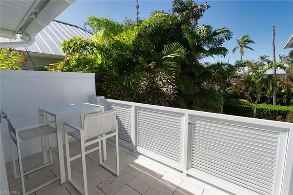 a view of a patio with table and chairs with wooden floor and plants