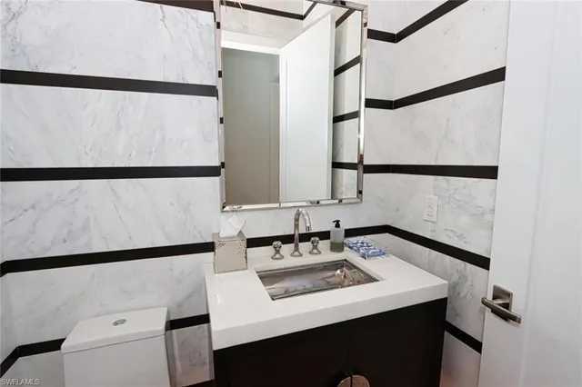 a bathroom with a sink and a refrigerator