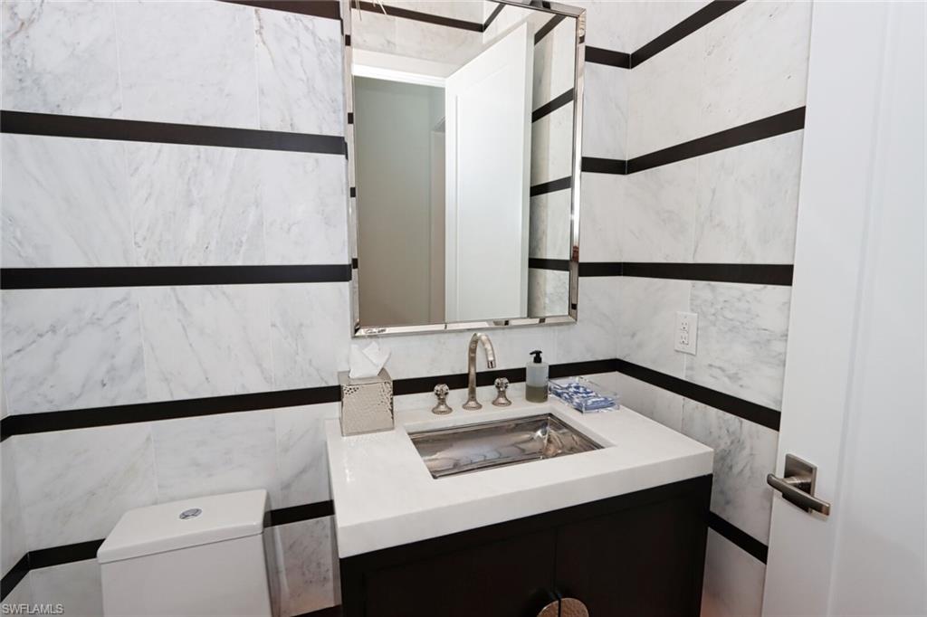 675 2nd Street South Naples, FL 34102 - Photo 28 of 31 a bathroom with a sink and a refrigerator