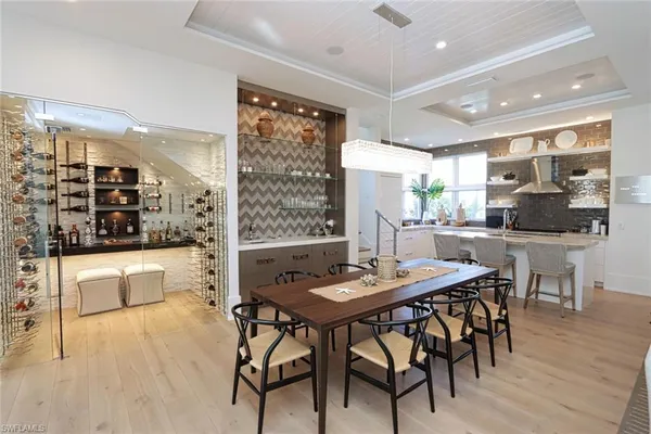 a dining hall with stainless steel appliances kitchen island granite countertop a table and chairs