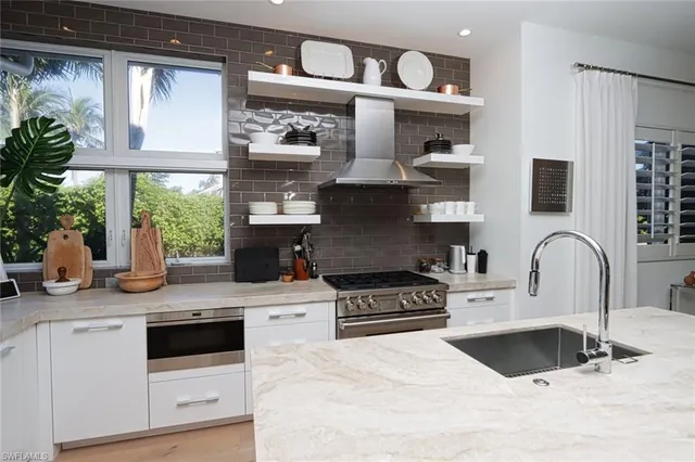 a kitchen with stainless steel appliances granite countertop a sink a stove and a wooden cabinets