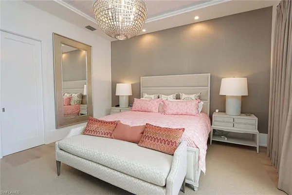a bedroom with bed and a chandelier