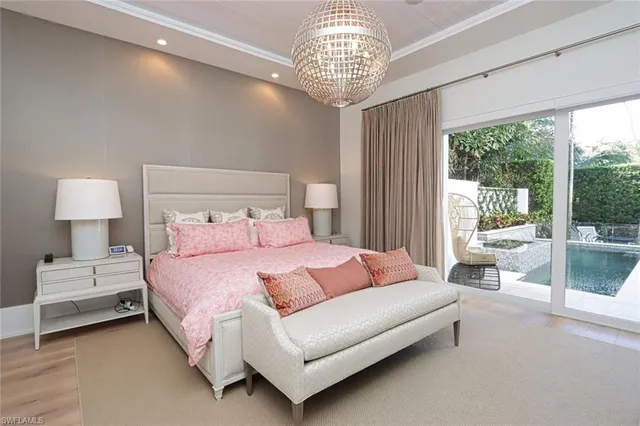 a bedroom with a large bed and a chandelier