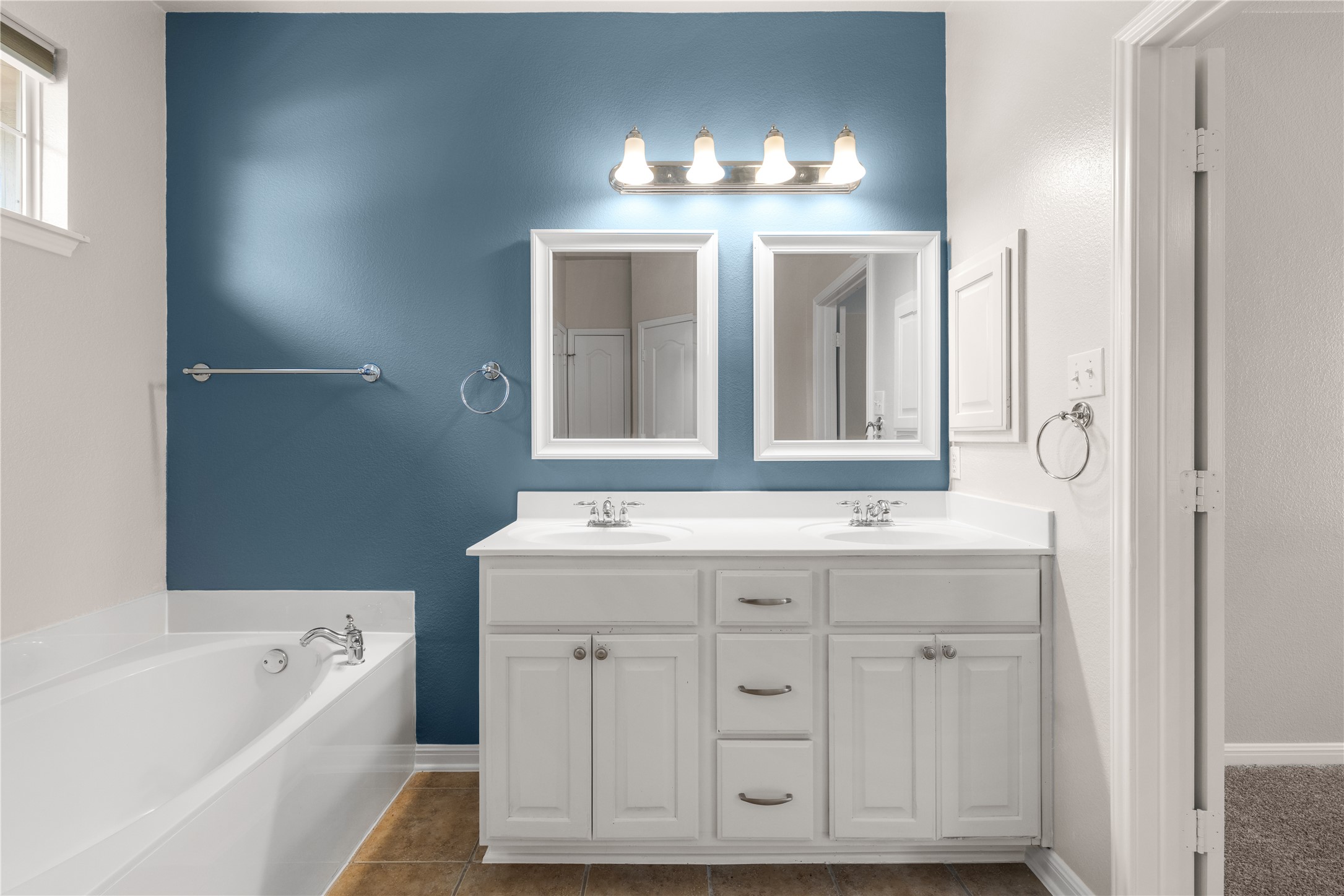 11000 Anderson Mill Road, Unit 45 Austin, TX 78750 - Photo 13 of 32 a bathroom with a double vanity sink a large mirror a bathtub and