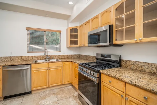 a kitchen with stainless steel appliances granite countertop a sink stove and cabinets