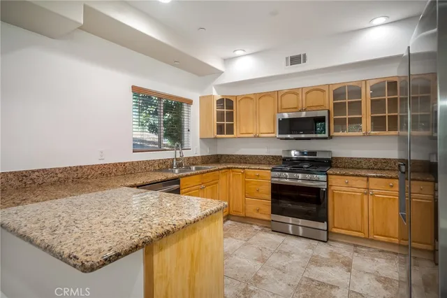 a kitchen with stainless steel appliances granite countertop a sink stove and microwave