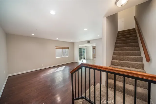 a view of a hallway with wooden floor and stairs