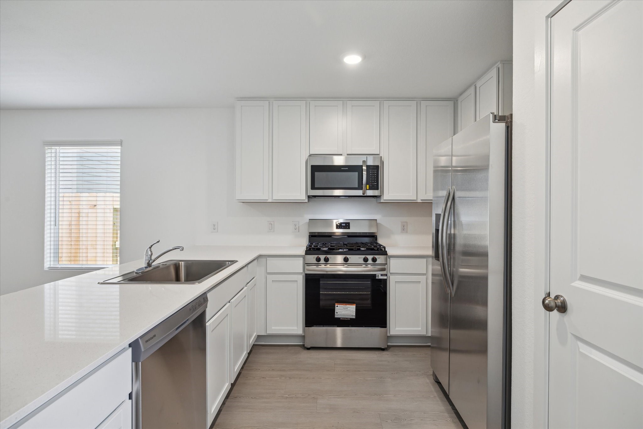 18015 Trepito Avenue New Caney, TX 77357 - Photo 5 of 14 a kitchen with stainless steel appliances granite countertop a refrigerator a sink a stove a microwave and island