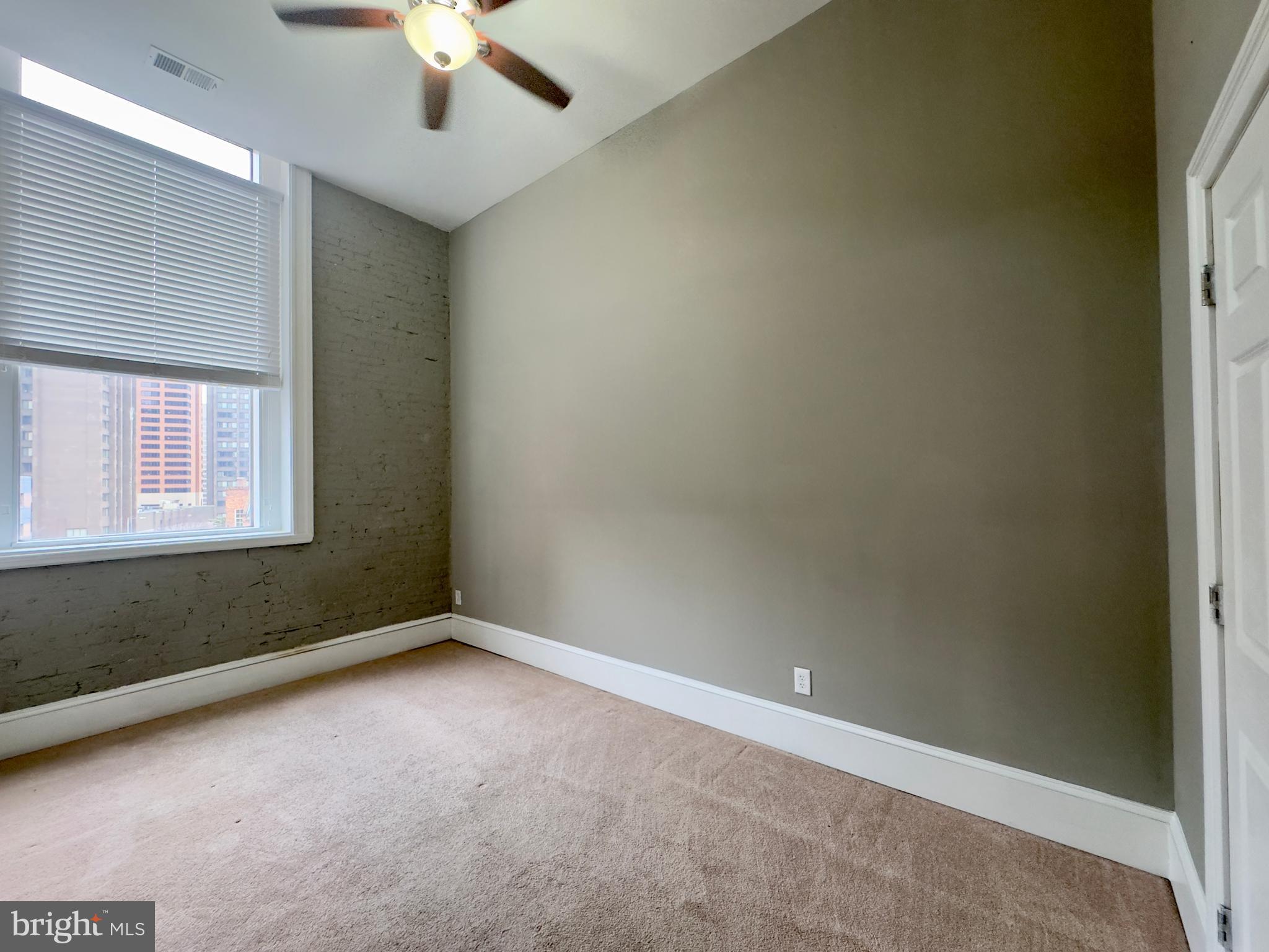 7 West Mulberry Street, Unit 7 Baltimore, MD 21201 - Photo 15 of 16 an empty room with a window and a fan