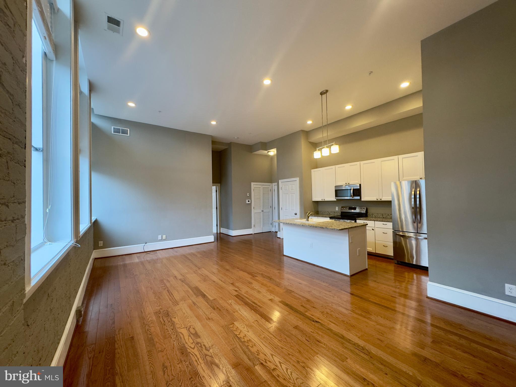 7 West Mulberry Street, Unit 7 Baltimore, MD 21201 - Photo 2 of 16 a view of kitchen with kitchen island stainless steel appliances counter space and wooden floor