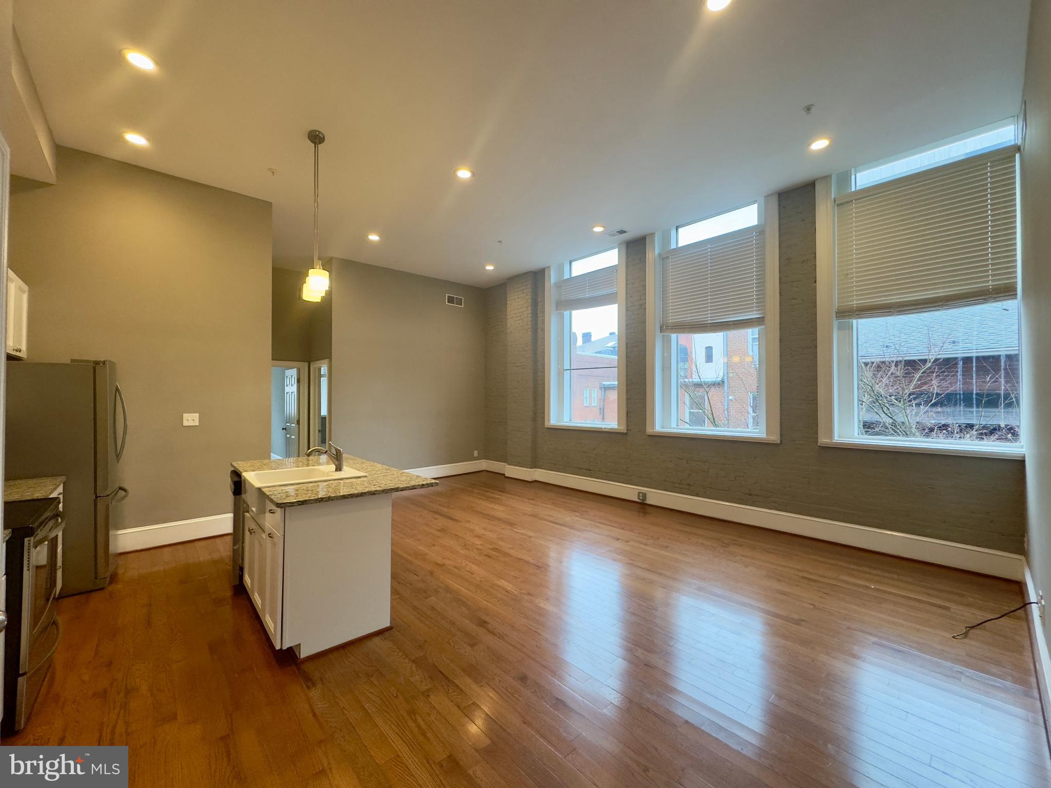 7 West Mulberry Street, Unit 7 Baltimore, MD 21201 - Photo 6 of 16 a view of an empty room with window and wooden floor