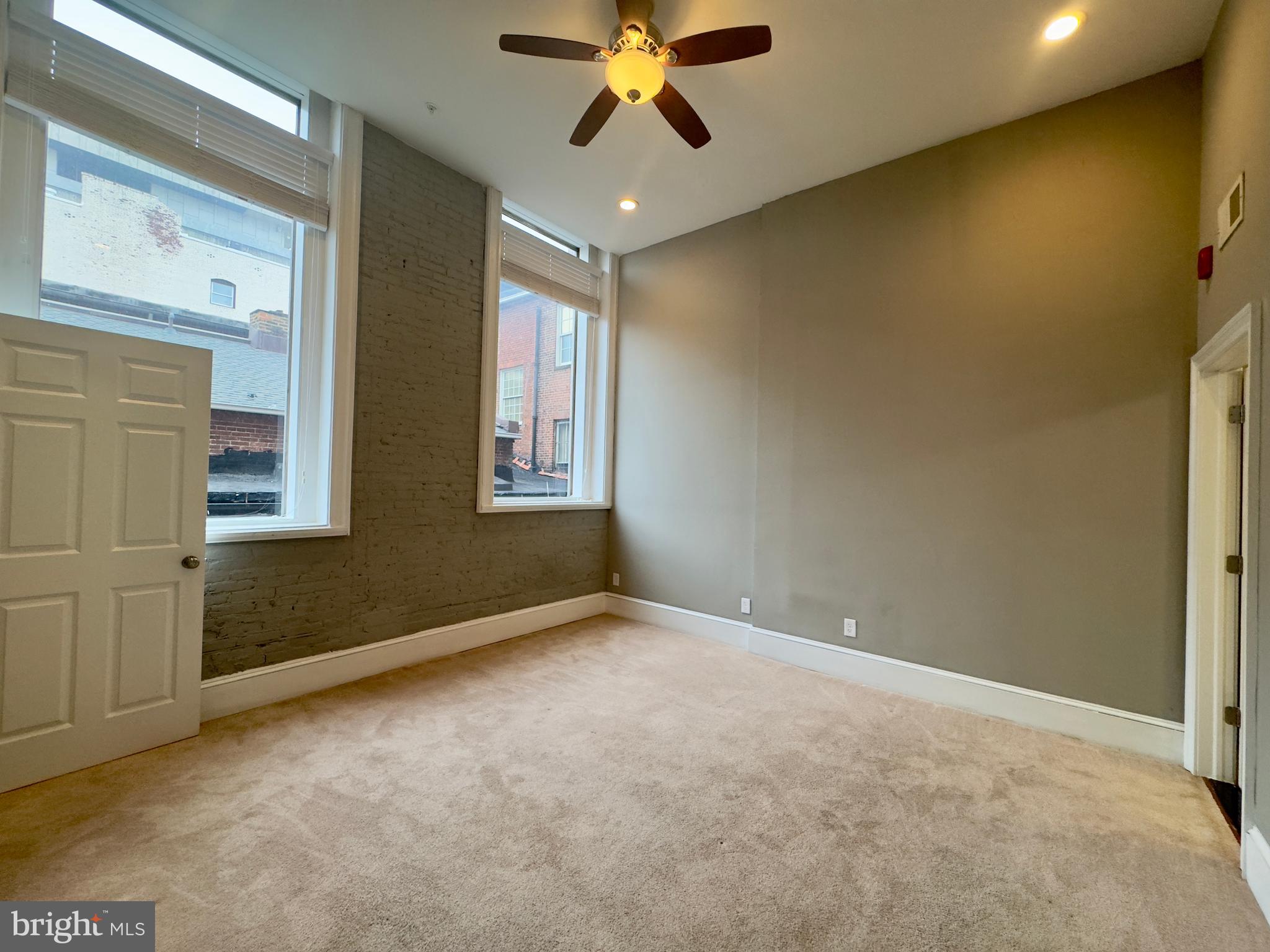 7 West Mulberry Street, Unit 7 Baltimore, MD 21201 - Photo 7 of 16 an empty room with windows and fan