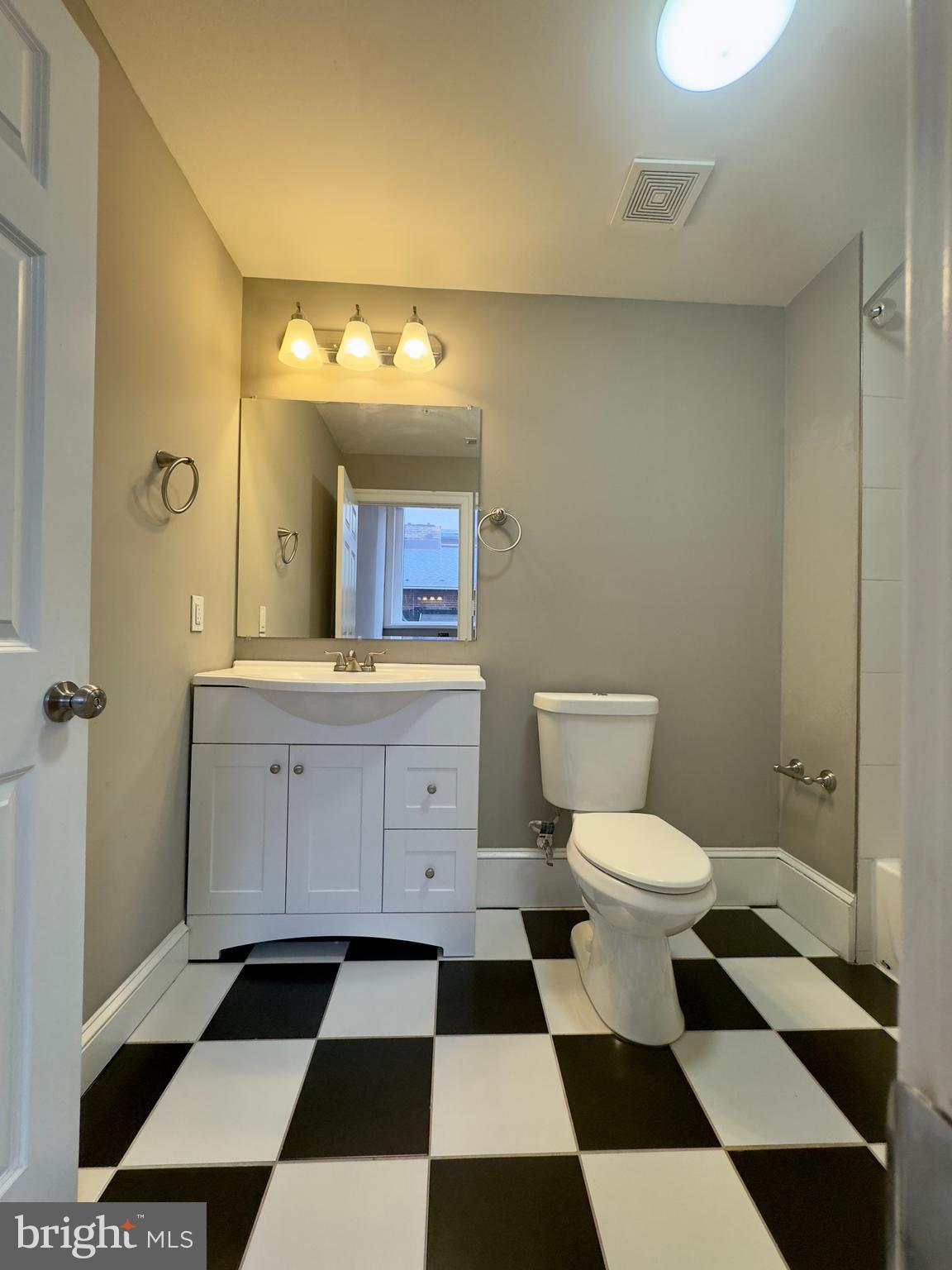 7 West Mulberry Street, Unit 7 Baltimore, MD 21201 - Photo 9 of 16 a bathroom with a black and white checkered floor