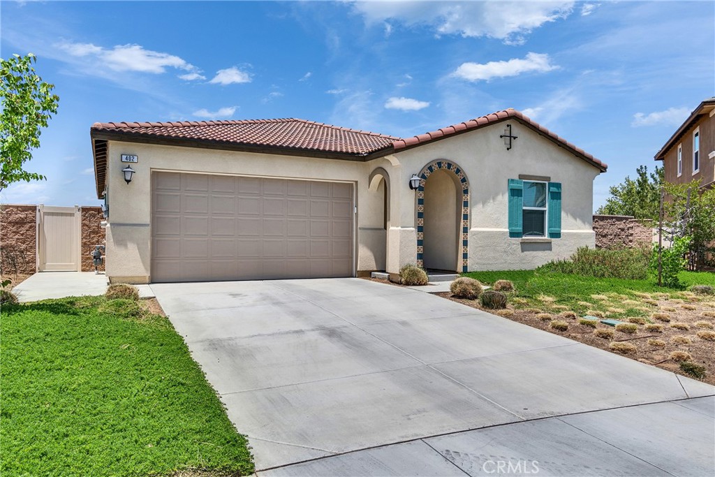 402 Appleton Way Perris, CA 92570 - Photo 11 of 34 a front view of a house with a yard and garage