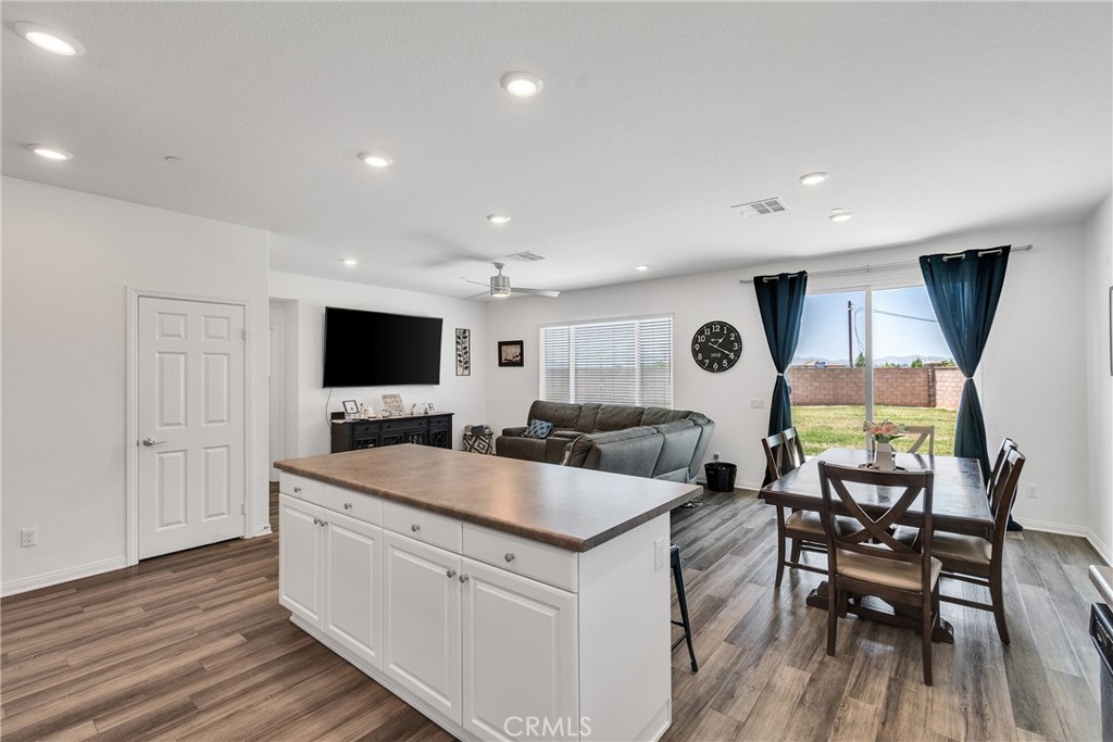 402 Appleton Way Perris, CA 92570 - Photo 25 of 34 a large room with kitchen island a flat screen tv and a table