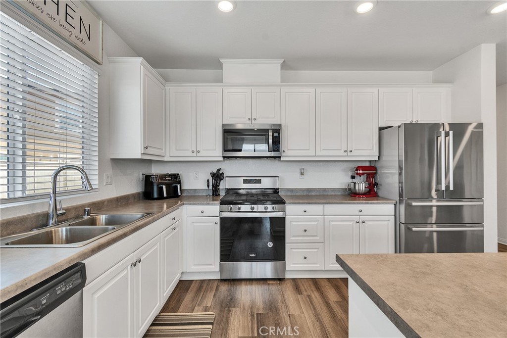 402 Appleton Way Perris, CA 92570 - Photo 30 of 34 a kitchen with a sink cabinets and stainless steel appliances