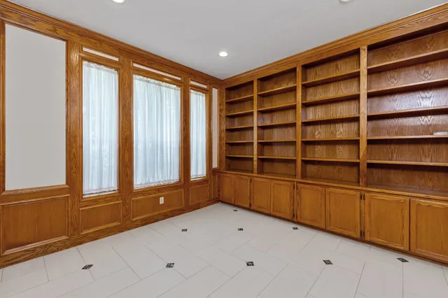 a view of an empty room with cabinet and a window