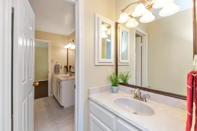 a bathroom with a granite countertop sink a mirror and a shower