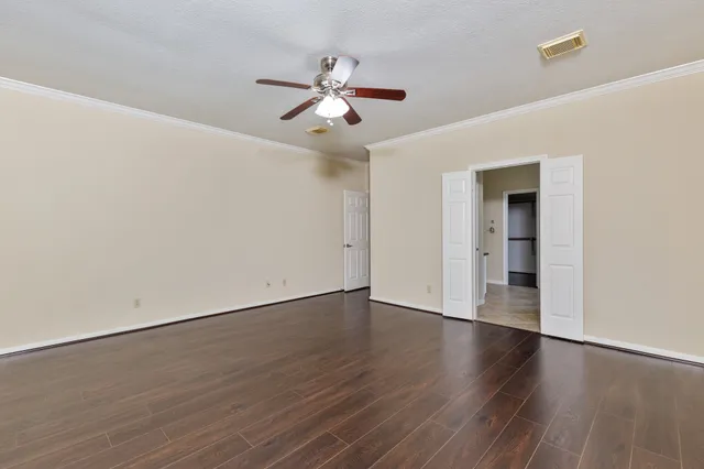a view of an empty room with wooden floor
