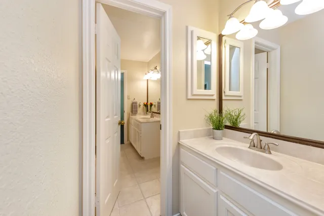 a en suite bathroom with a granite countertop sink and a mirror